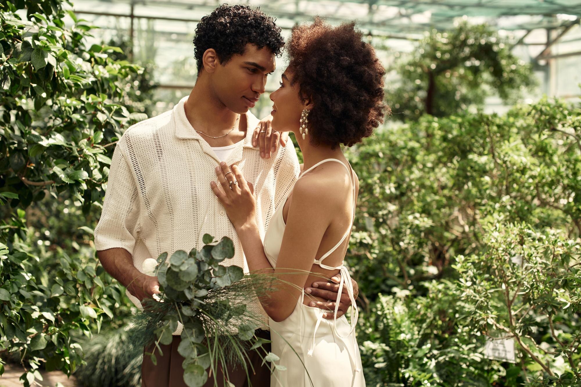 Couple embraces in a lush greenhouse - We do events