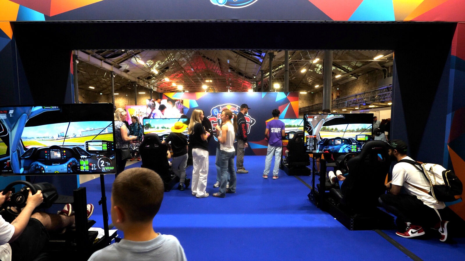 Row of F1 racing simulators at a live event
